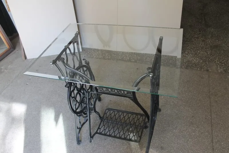 Stolik ze szklanym blatem na podstawie maszyny do szycia